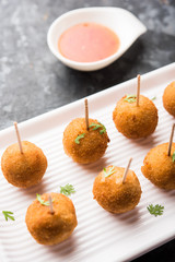 Crispy Veg lollipop recipe made using boiled potato with spices covered with corn flour and bread crumbs coating and then deep fried, served with toothpick or ice cream stock inserted in it with sauce