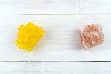 The pink Himalayan salt crystal  and yellow sugar crystal, the concept of the two main tastes of life - sweet and salty. White background with copy space