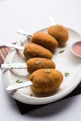 Crispy Veg lollipop recipe made using boiled potato with spices covered with corn flour and bread crumbs coating and then deep fried, served with toothpick or ice cream stock inserted in it with sauce