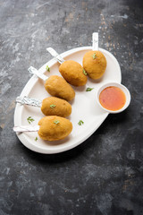 Crispy Veg lollipop recipe made using boiled potato with spices covered with corn flour and bread crumbs coating and then deep fried, served with toothpick or ice cream stock inserted in it with sauce