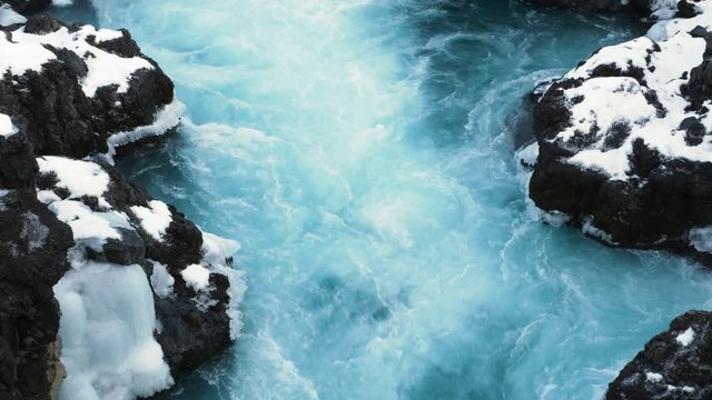 Ice blue glacial water flowing at Barnafoss waterfall in Iceland
