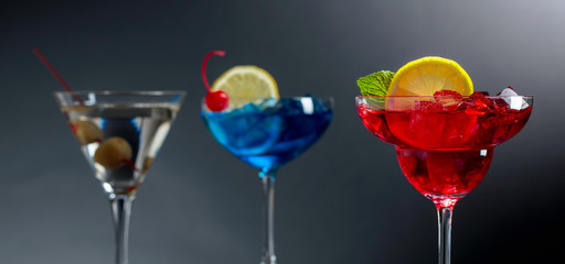 Two colorful cocktails and dry martini with green olives.