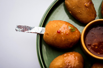 Crispy Veg lollipop recipe made using boiled potato with spices covered with corn flour and bread crumbs coating and then deep fried, served with toothpick or ice cream stock inserted in it with sauce