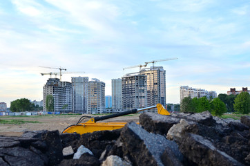 Tower cranes constructing a new building at a construction site on the sunset and blue sky background. Concept of the building industry - Image