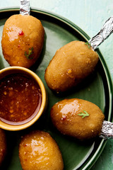 Crispy Veg lollipop recipe made using boiled potato with spices covered with corn flour and bread crumbs coating and then deep fried, served with toothpick or ice cream stock inserted in it with sauce