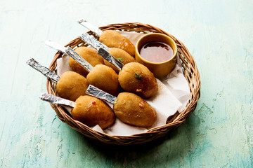 Crispy Veg lollipop recipe made using boiled potato with spices covered with corn flour and bread crumbs coating and then deep fried, served with toothpick or ice cream stock inserted in it with sauce