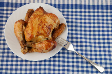 Grilled chicken in white plate on blue tablecloth