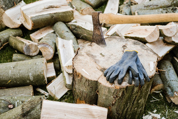An axe on a log next to a chopped firewood