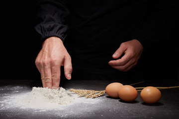 Female hands making cloud of flour. Cook clap hands with flour in the kitchen. Cooking dough for bread, pizza or pasta