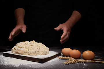 man Baker and his hands over the bread from whole wheat flour (to oven). flour, rustic style
