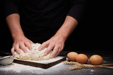 man Baker and his hands over the bread from whole wheat flour (to oven). flour, rustic style