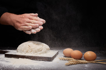 man Baker and his hands over the bread from whole wheat flour (to oven). flour, rustic style