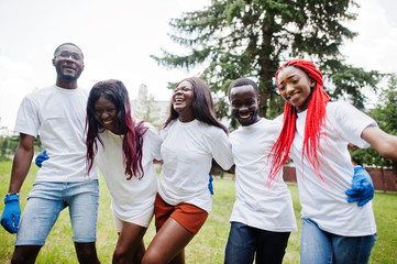 Group happy african volunteers hugs together in park. Africa volunteering, charity, people and...