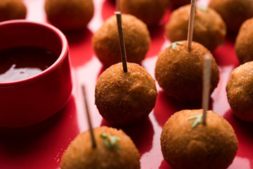 Crispy Veg lollipop recipe made using boiled potato with spices covered with corn flour and bread crumbs coating and then deep fried, served with toothpick or ice cream stock inserted in it with sauce