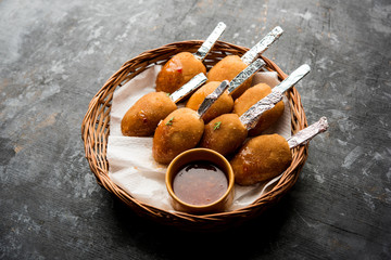 Crispy Veg lollipop recipe made using boiled potato with spices covered with corn flour and bread crumbs coating and then deep fried, served with toothpick or ice cream stock inserted in it with sauce