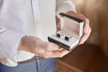 men's hands holding a box with cufflinks