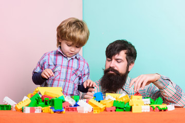 fathers day. building home with colorful constructor. child development. little boy with bearded man dad playing together. father and son play game. happy family. leisure time. fathers day concept