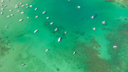 Aerial shot of local boats in El Nido Beach, Palawan, Philippines.Many white boats in the turquoise lagoon, view from above.
