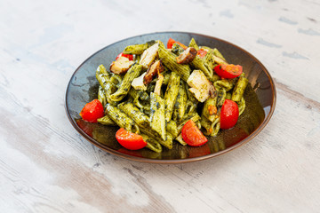 Penne cooked cereal specialty with cooked chicken fillets and a sauce made with olive oil