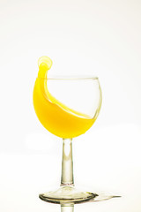 Splash of juise in a glass on white background. Close up.