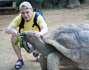The man the tourist feeds a turtle