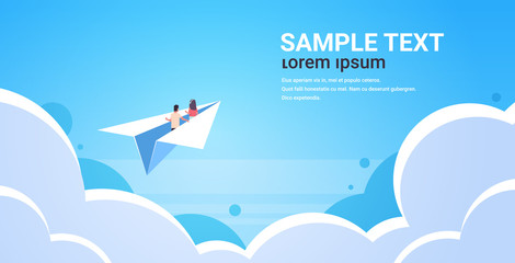 couple in love flying on paper airplane man woman lovers traveling together romantic concept blue sky background with clouds flat horizontal copy space