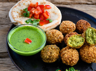 Close up of fresh falafel balls with pesto sauce and  pita bread. Selective focus.