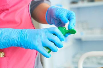 Nurse holding a medical solution for dropper in hands and prepare to putting medicine inside it. Injection preparation in hospital.