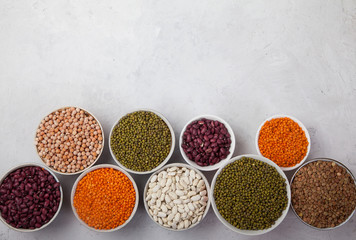 Red and white beans, green and red lentils, sunflower and pumpkin  in cups on a white background. superfood