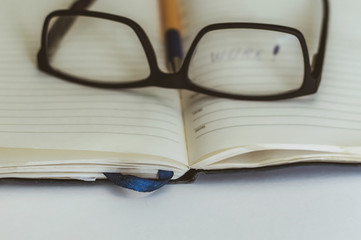 black glasses lie on the book on the table, rest in the process of education