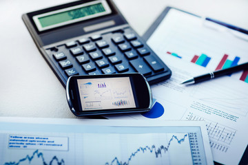 Naklejka na ściany i meble close up. calculator, mobile phone and financial charts on the table
