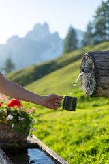 Close up shot of the tourist hand holding green mug in mountains.
