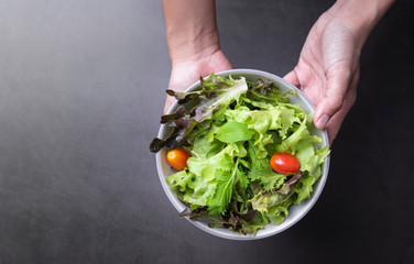 Fresh healthy vegetable salad with tomato, carrot, spinach, lettuce in plate on table background with free text space for diet menu.