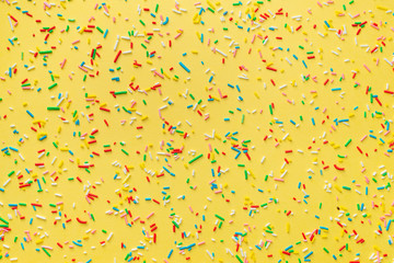 colorful sprinkles over yellow background, decoration for festive Valentines day, birthday, holiday...