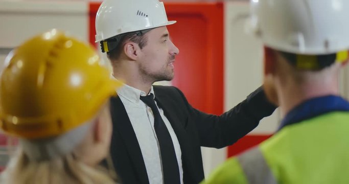 Factory owner talking to workers