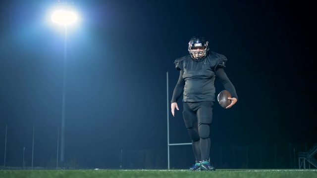 American football ball is being saved by a football player on a stadium