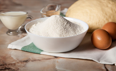 Bakery ingredients. On the table are flour, eggs and pastry dough