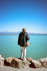 middle-aged man looking the water. Lonely traveller standing on the shore