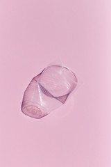 pastel pink background with compressed plastic glass