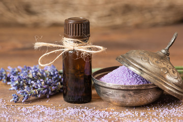 Lavender flowers, bath salt and lavender oil on a wooden background.