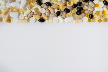 Scattered colorful pills on white table. Mock up for advertising or web background. Health care, Medical or Pharmacy concept. Copy space. Empty place for text or logo.