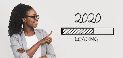 Positive african business woman pointing at 2020 loading bar