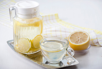   Lemon water in a glass jug and in a glass cup