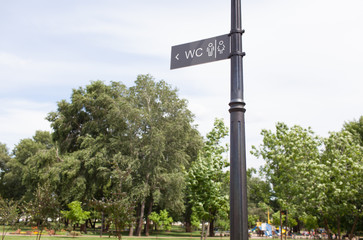 Restroom sign on gray board in park