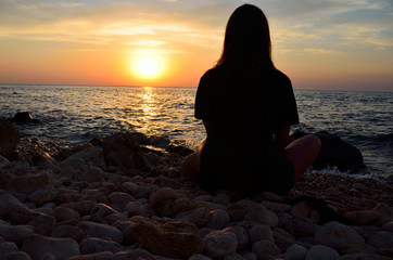 Single adult woman silhouette and sunset on sea