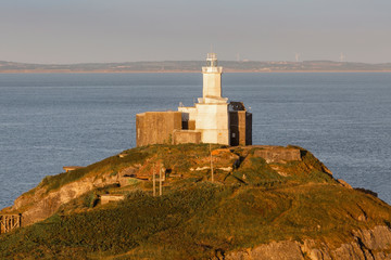Fototapeta na wymiar Mumbles Lighthouse The iconic landmark that is Mumbles Lighthouse on the Gower peninsula in Swansea, South Wales, UK.