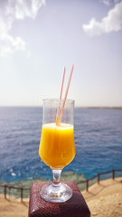 glass of fresh mango on the table on sea background