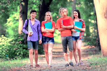 group of happy young students walking outdoors. Looking aside