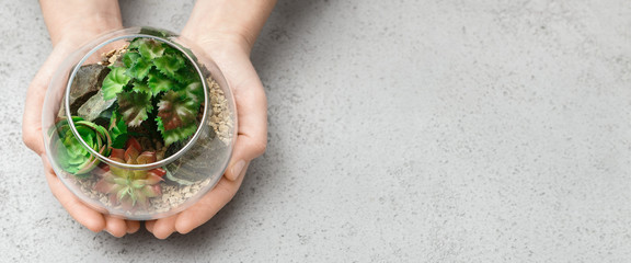 Woman holding mini glass florarium, copy space