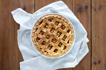 food, culinary and baking concept - close up of apple pie in mold on wooden table